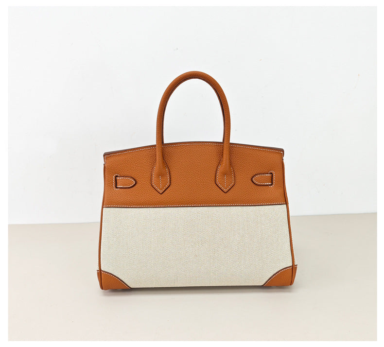 Top Handle Bag in Pebbled Grain Leather & Canvas with Gold-Tone Twist Lock detail image 1